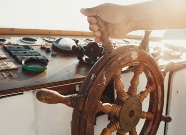 Sun shines over the wooden wheel held by man