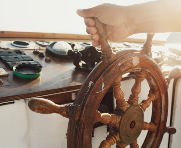 Sun shines over the wooden wheel held by man